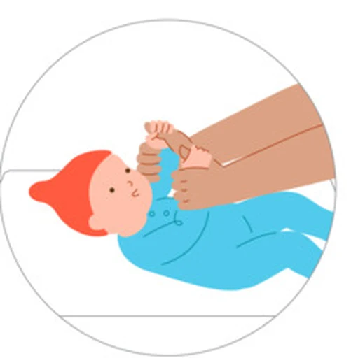 A baby reaches toward a caregiver’s hands during floor play.