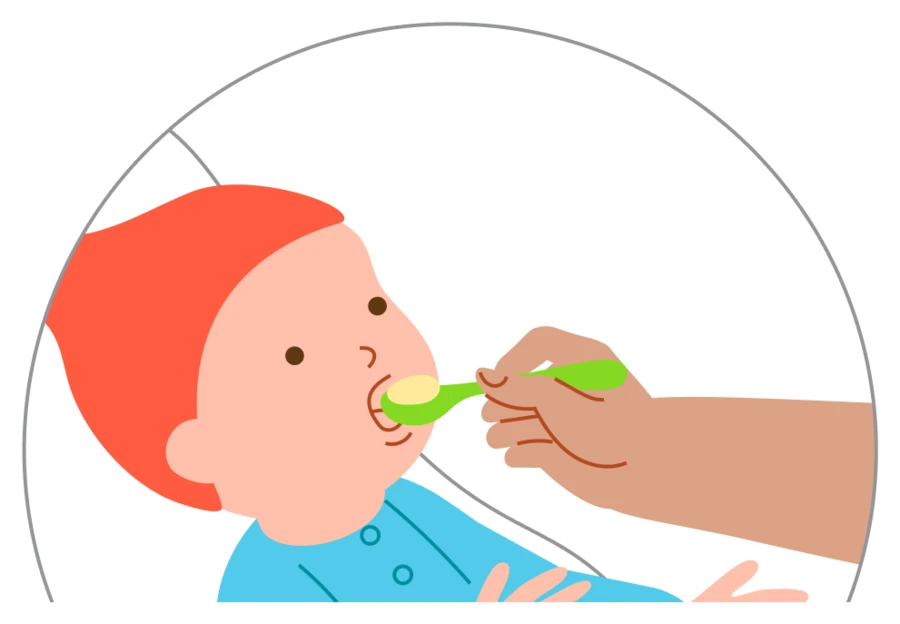 A caregiver offers a small spoonful of the baby’s planned food and waits for a response.